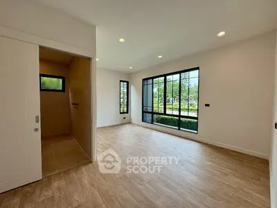 Spacious modern living room with large windows and wooden flooring