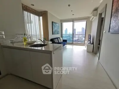 Modern open-layout living room with city view, featuring sleek kitchen and stylish decor.