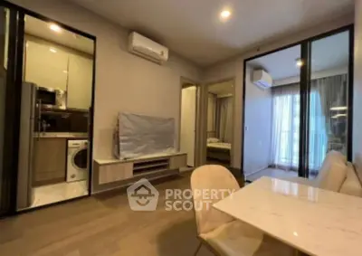 Modern apartment interior with open living space and kitchen, featuring sleek design and natural light.