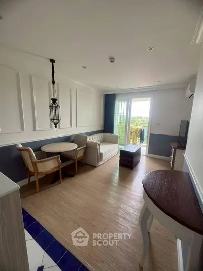 Charming living room with elegant decor and balcony view, perfect for relaxation.