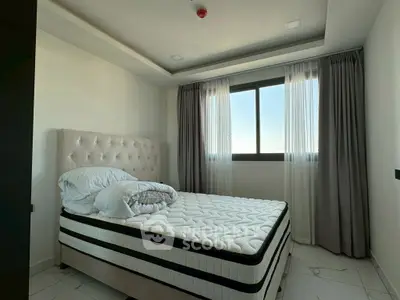 Modern bedroom with large window and stylish bed in a bright apartment.