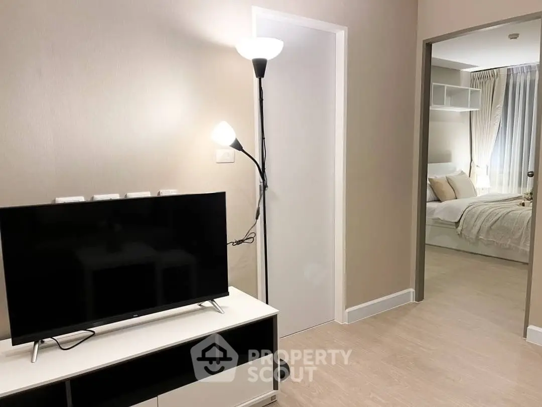 Modern living room with TV and cozy bedroom view, perfect for urban living.