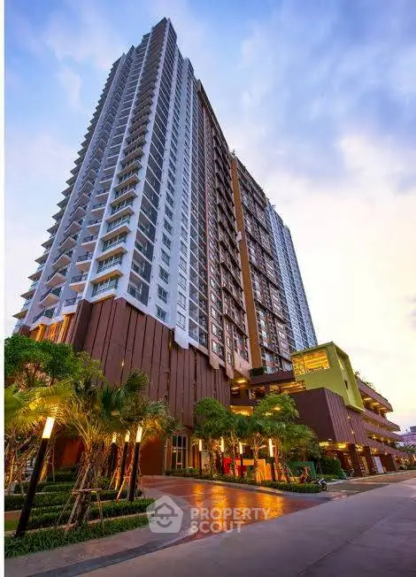 Stunning high-rise building with modern architecture and lush landscaping at sunset.