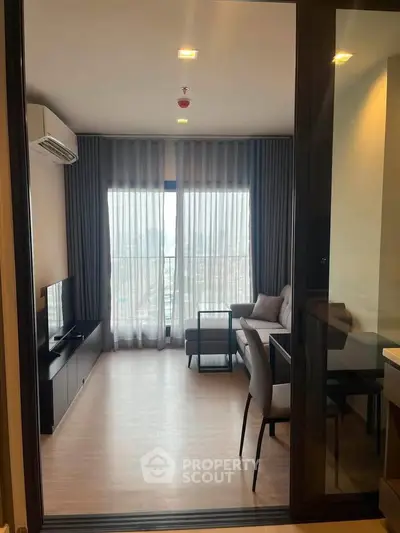 Modern living room with floor-to-ceiling windows and stylish furniture in a high-rise apartment.