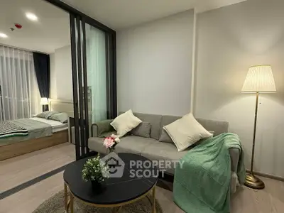 Modern living room with cozy sofa and stylish decor adjacent to a bedroom