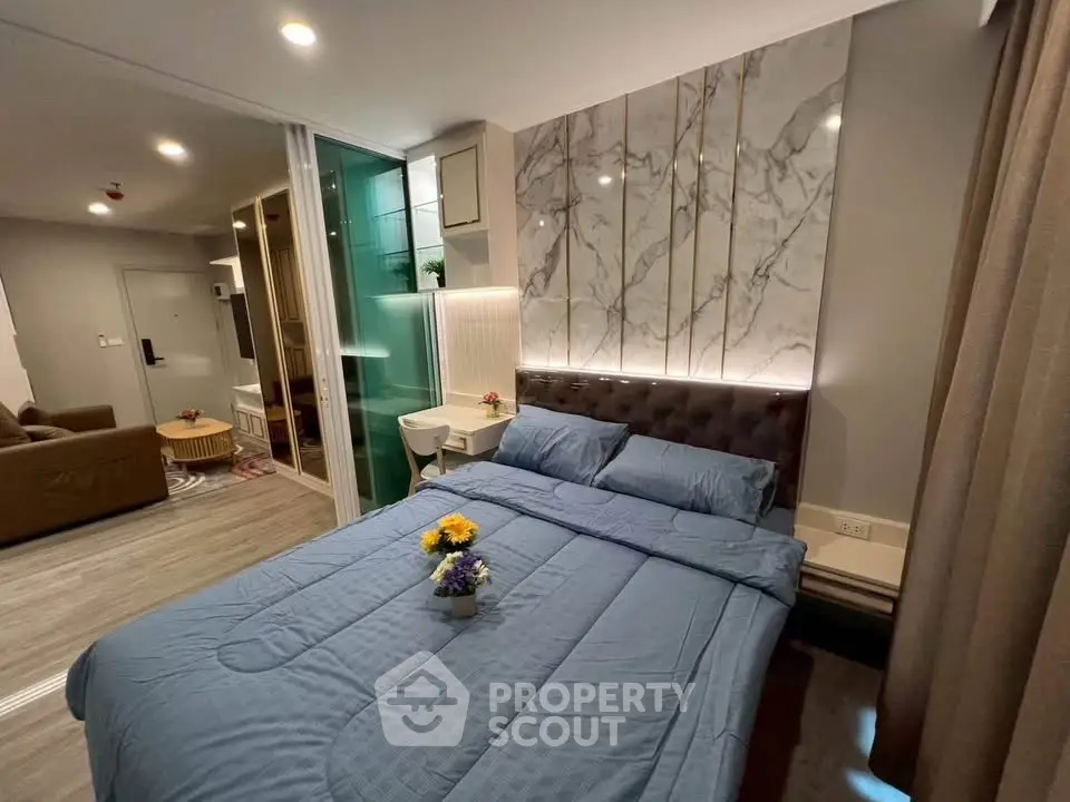Modern bedroom with elegant decor and cozy ambiance, featuring a plush bed and stylish lighting.