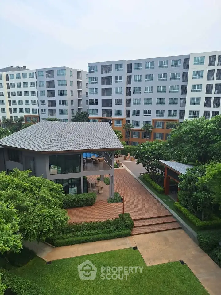 Modern apartment complex with lush greenery and spacious courtyard view.