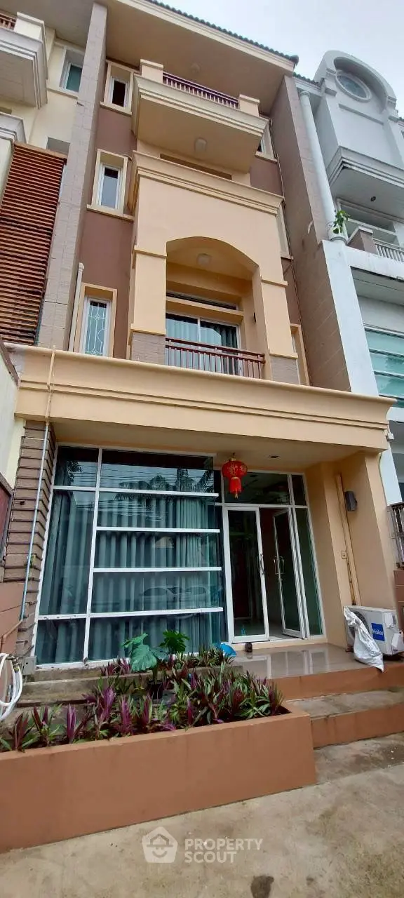 Elegant multi-story residential building with modern facade and landscaped entrance.