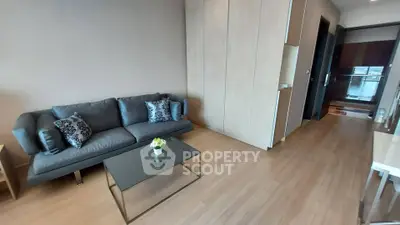 Modern living room with sleek sofa and glass coffee table in stylish apartment.