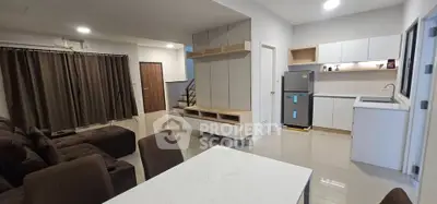 Modern open-plan living room and kitchen with sleek design and ample natural light.