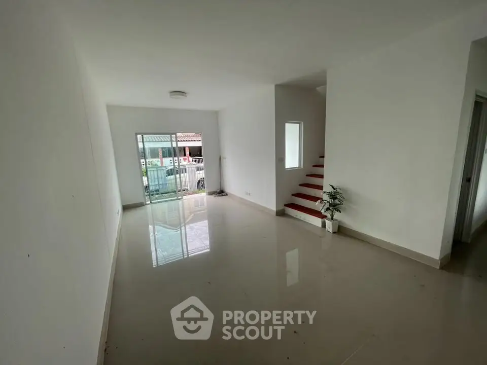Spacious living room with glossy floors and balcony access in modern home