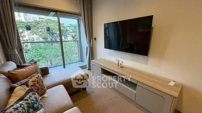 Modern living room with large TV and balcony view in a stylish apartment.