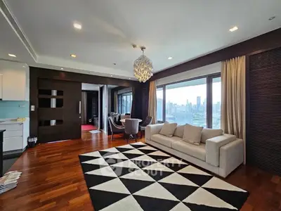 Luxurious living room with stunning city view, elegant chandelier, and modern decor in high-rise apartment.