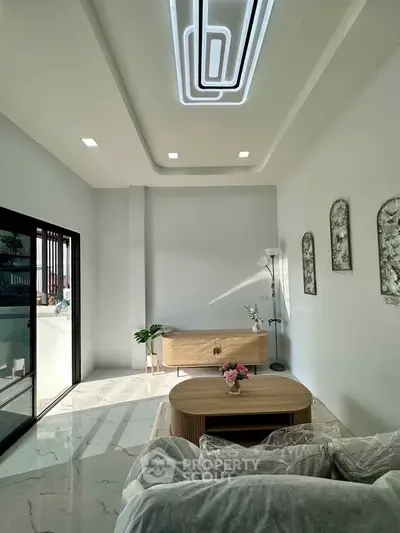 Modern living room with stylish ceiling lights and elegant decor, featuring a cozy seating area and natural light.