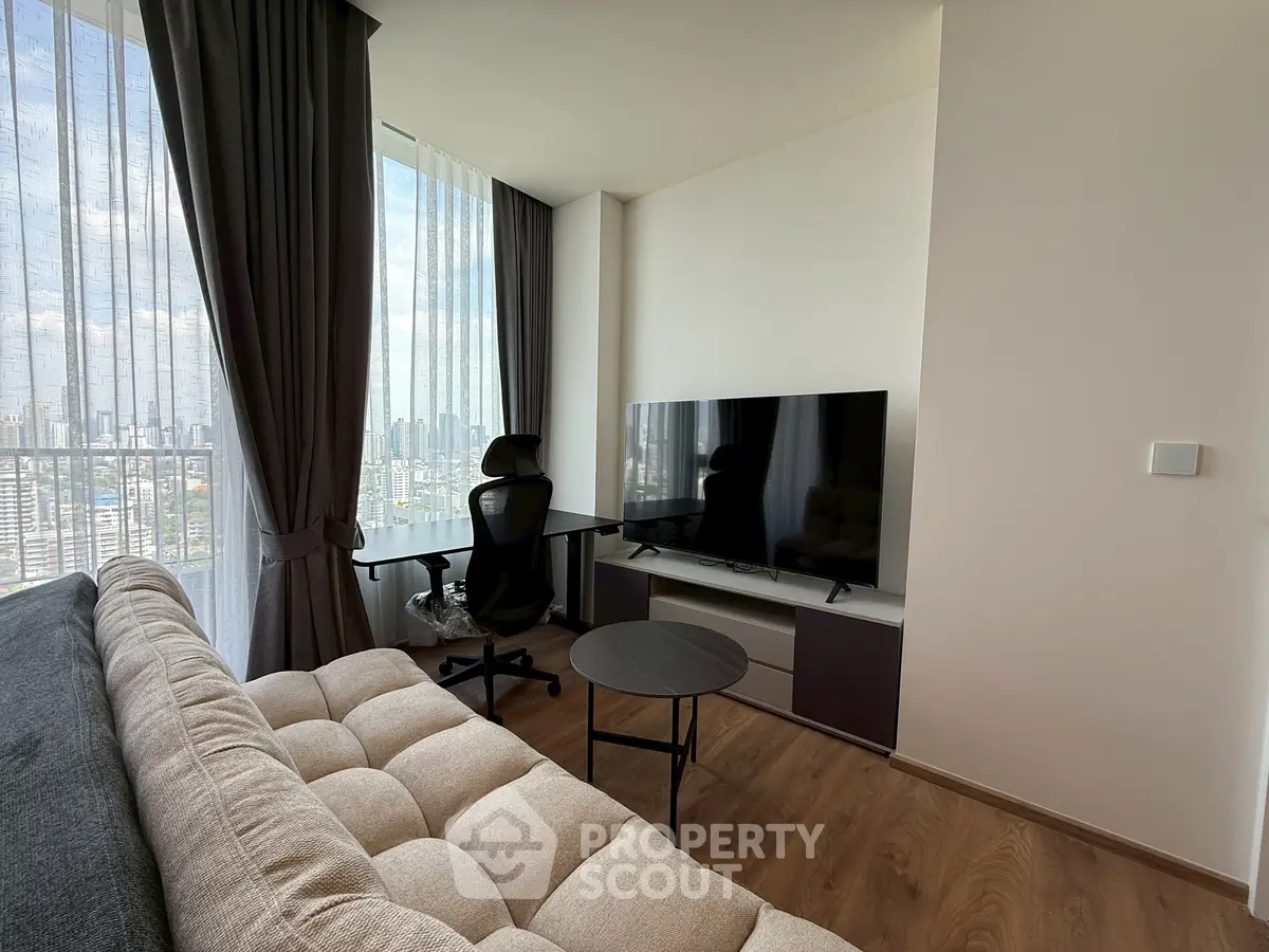 Modern living room with city view, featuring a cozy sofa, sleek TV setup, and stylish workspace.