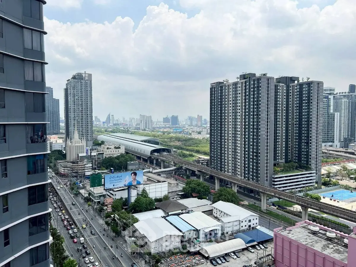 Stunning cityscape view from high-rise apartment overlooking urban skyline and transportation hub.