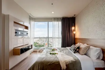 Modern bedroom with large window offering stunning city view and stylish decor.