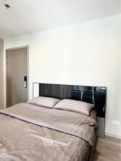 Modern bedroom with stylish bed and neutral decor in a contemporary apartment.