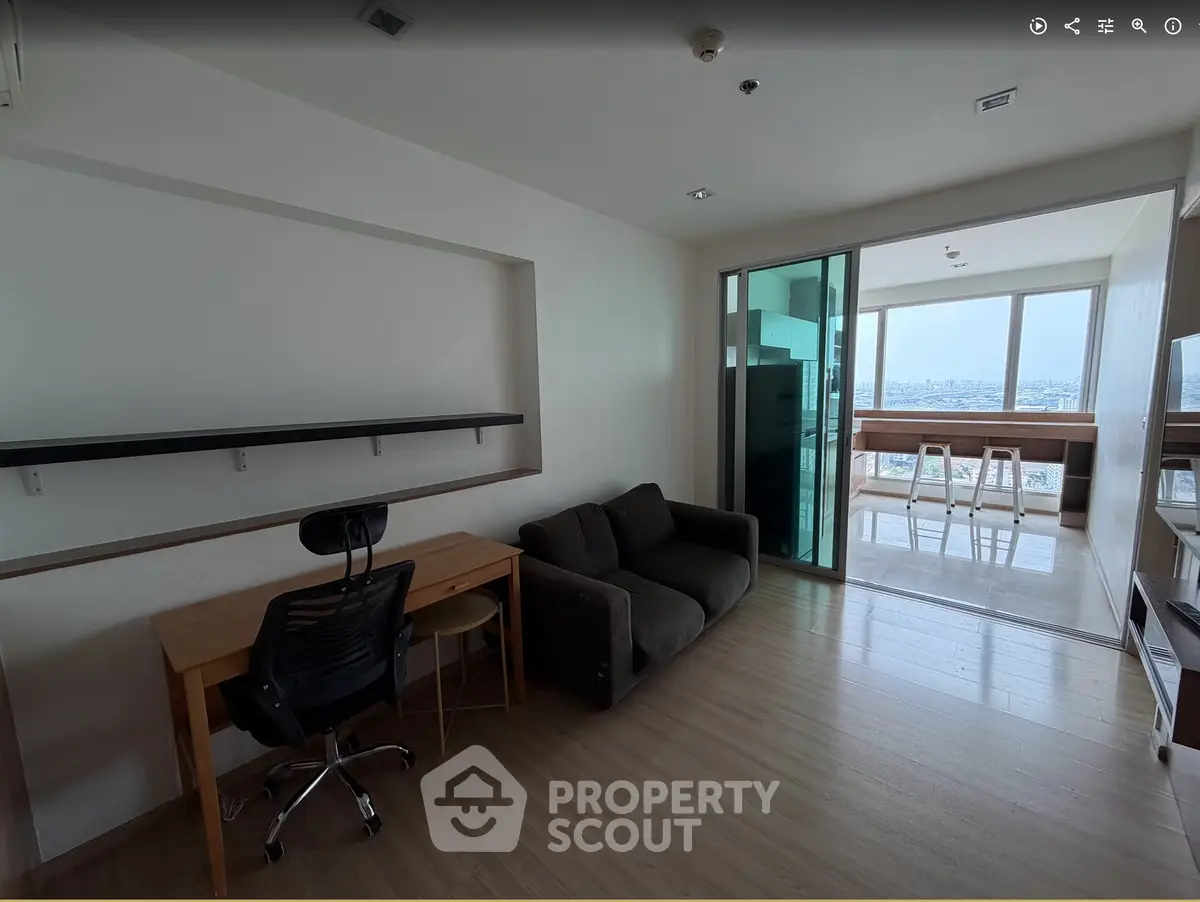 Modern apartment with study area and bright living space featuring large windows and city view.