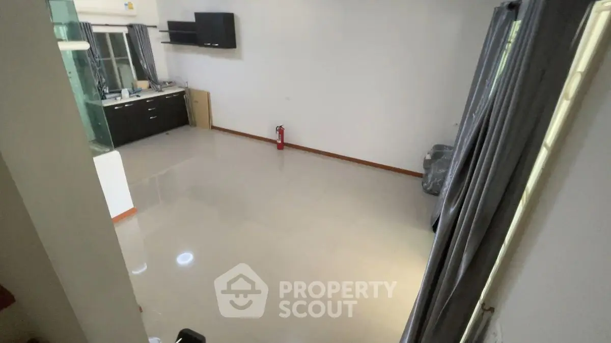 Spacious living room with modern kitchen and large windows for natural light.