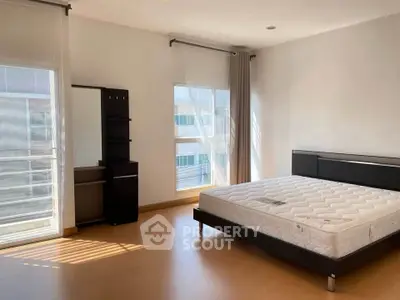 Spacious bedroom with large windows and modern furniture, perfect for natural light lovers.