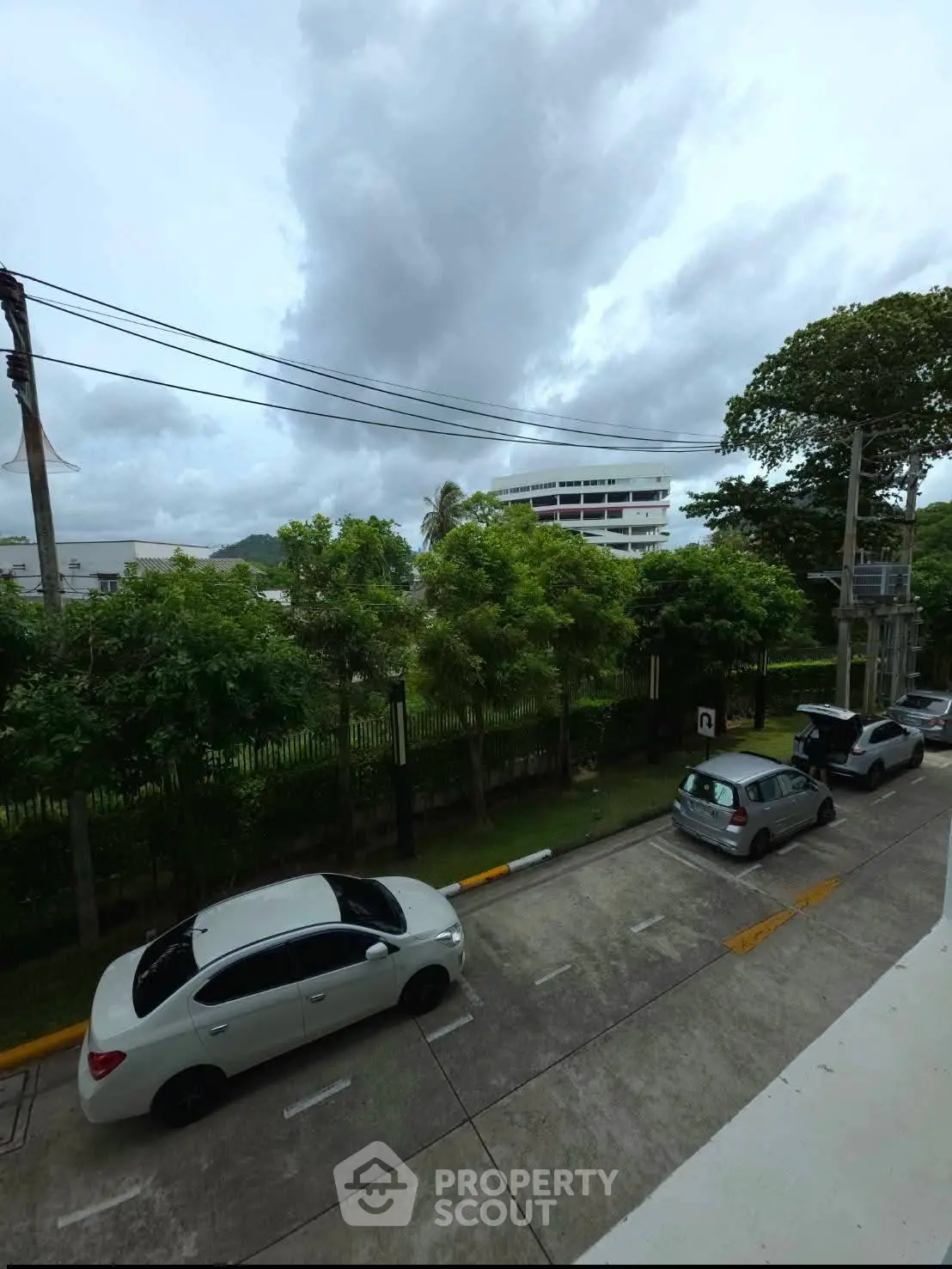 Scenic view from balcony overlooking street and lush greenery, perfect for urban nature lovers.