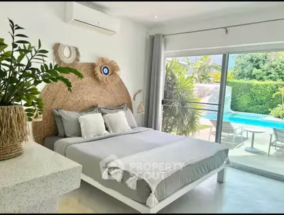 Luxurious bedroom with pool view, stylish decor, and natural light in a modern home.
