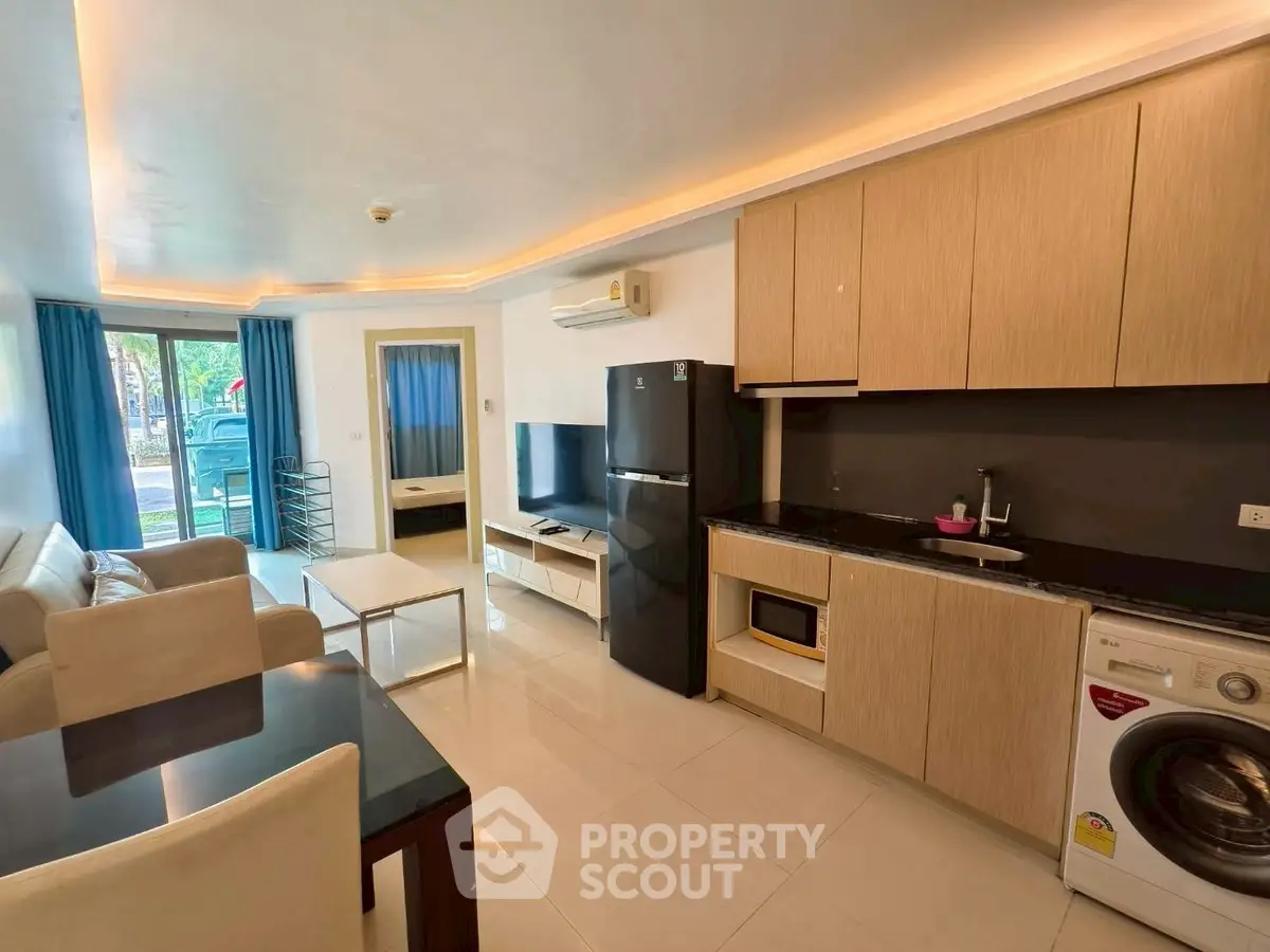 Modern open-plan living room with kitchen, featuring sleek appliances and stylish furniture.