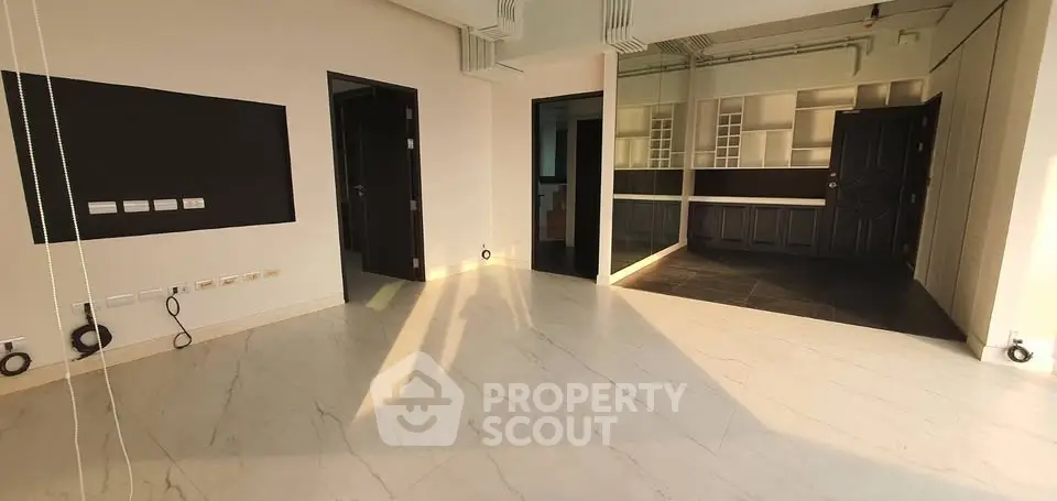 Spacious modern living room with open layout and elegant flooring, perfect for contemporary living.