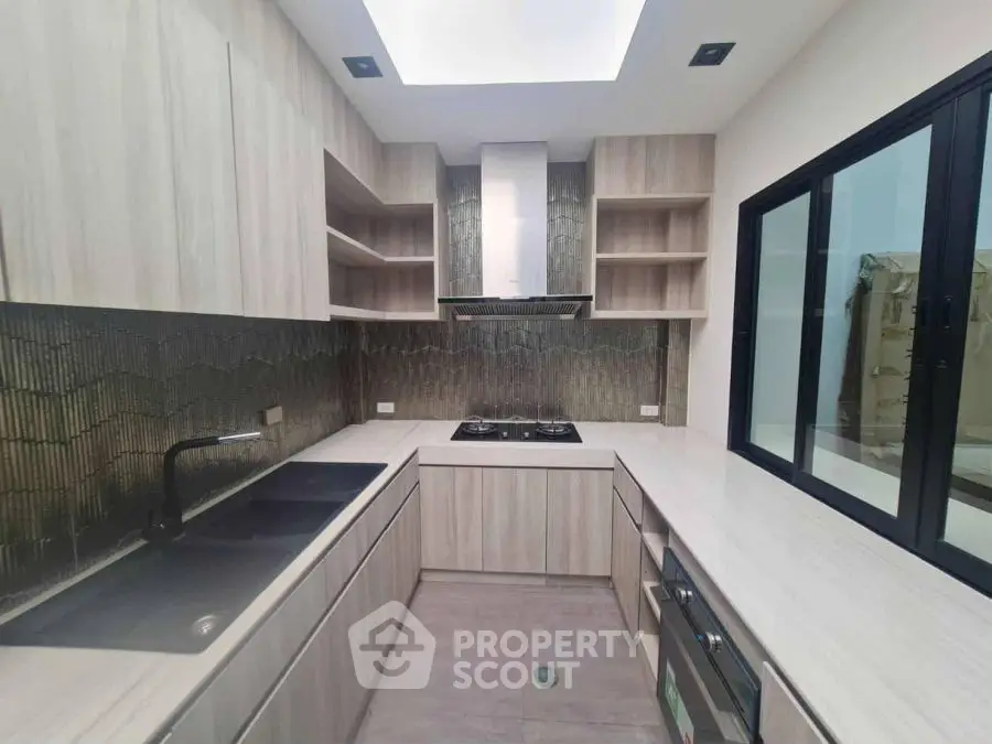Modern kitchen with sleek cabinetry and gas stove in contemporary home.