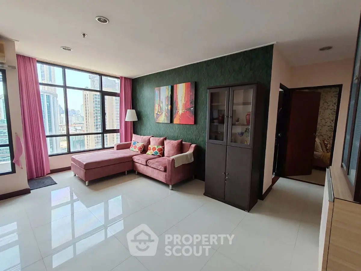 Spacious living room with city view, modern decor, and large windows in urban apartment.