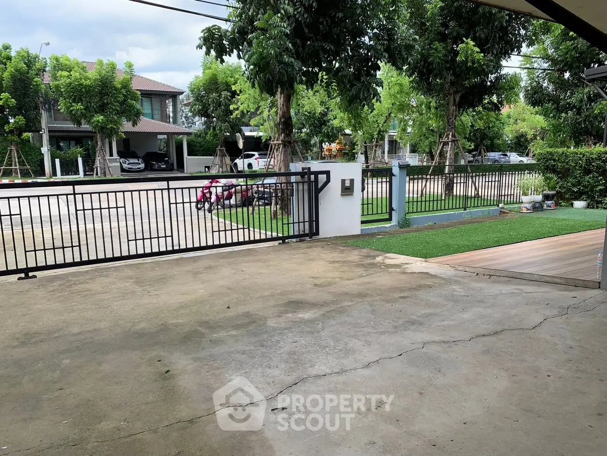 Spacious driveway with gated entrance in a serene neighborhood