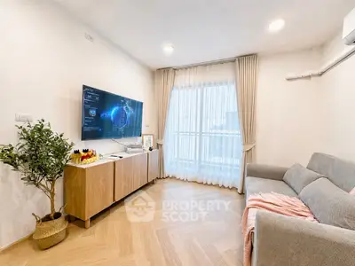 Modern living room with stylish decor, large TV, and cozy sofa in a bright apartment.