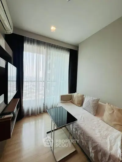 Modern living room with large window and stylish furniture in a high-rise apartment.