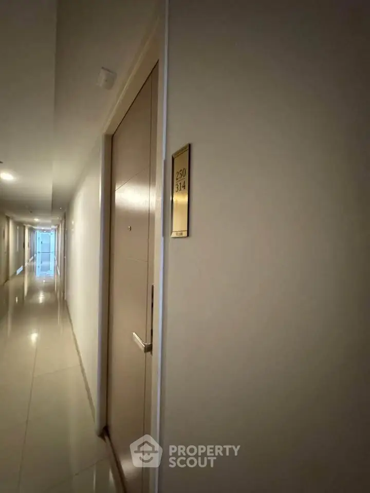 Modern apartment hallway with sleek design and room number signage.