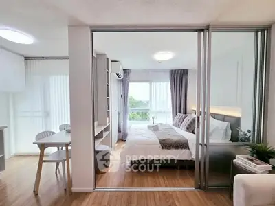 Modern bedroom with sliding glass doors and natural light in stylish apartment.