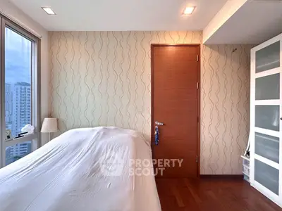 Modern bedroom with city view, featuring stylish wallpaper and wooden flooring.