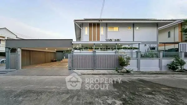 Modern two-story house with spacious driveway and sleek design.