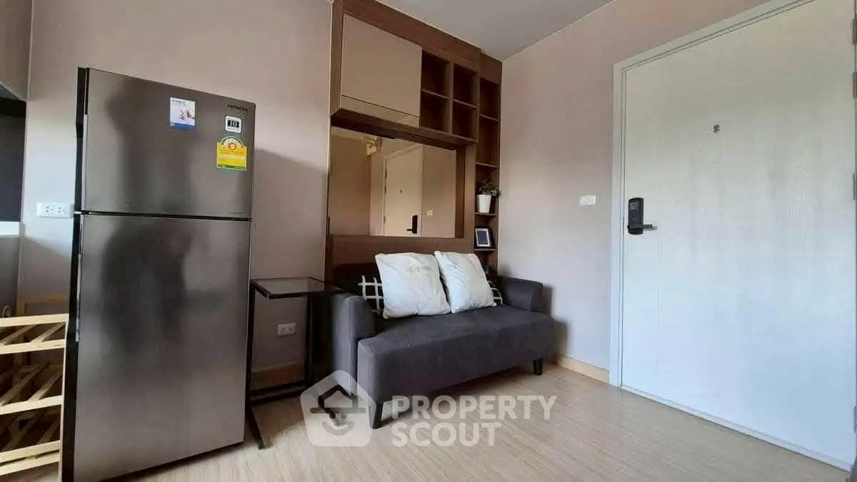 Modern compact living room with fridge and sofa in cozy apartment