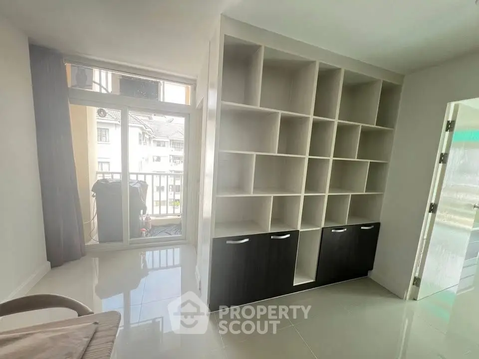 Modern study room with built-in shelving and balcony access