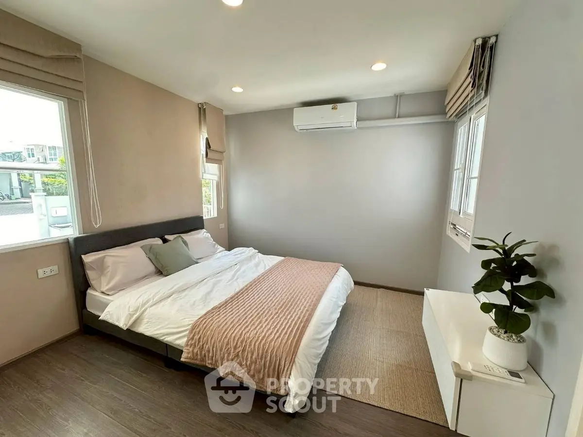 Spacious bedroom with modern decor and natural light, featuring a comfortable bed and stylish furnishings.