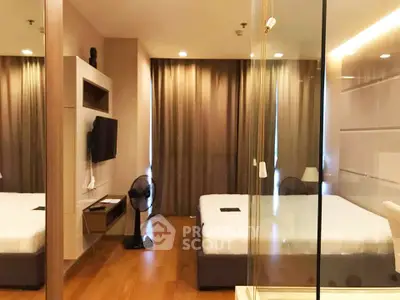 Modern bedroom with wooden flooring and glass partition, featuring a cozy bed and wall-mounted TV.