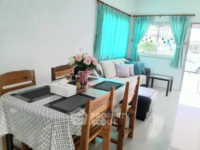 Charming living room with dining area, bright windows, and cozy seating, perfect for family gatherings.