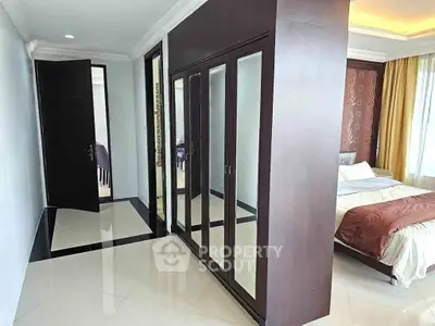 Spacious bedroom with mirrored wardrobe and elegant decor