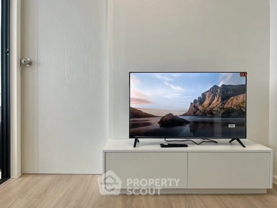 Modern living room with sleek TV setup on minimalist white stand, showcasing elegant interior design.
