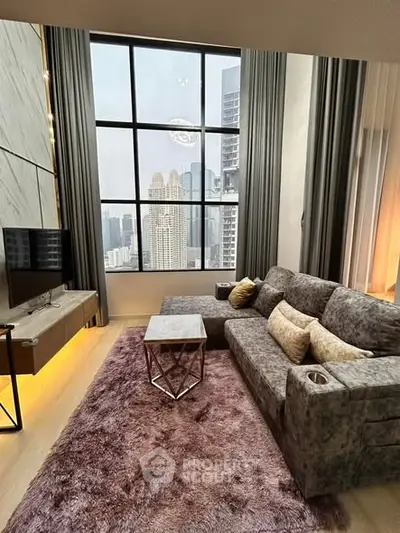 Luxurious living room with stunning city view, plush sofa, and elegant decor in a high-rise apartment.