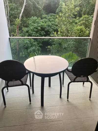 Charming balcony with forest view, featuring a cozy table and chairs for serene outdoor relaxation.