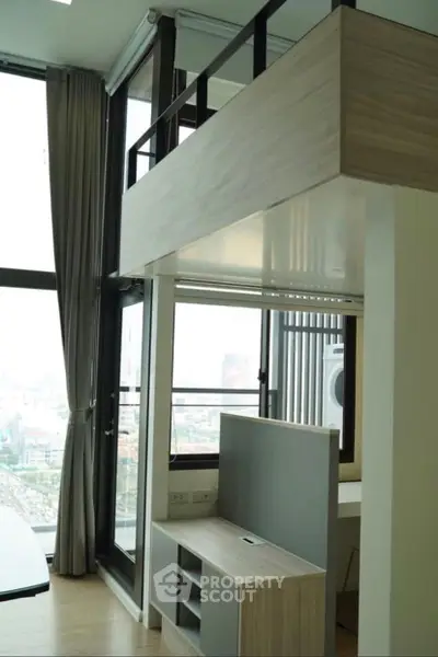 Modern loft-style apartment with high ceilings and large windows offering city views.