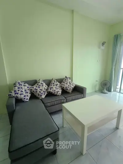 Cozy living room with modern gray sofa and floral cushions, perfect for relaxation.