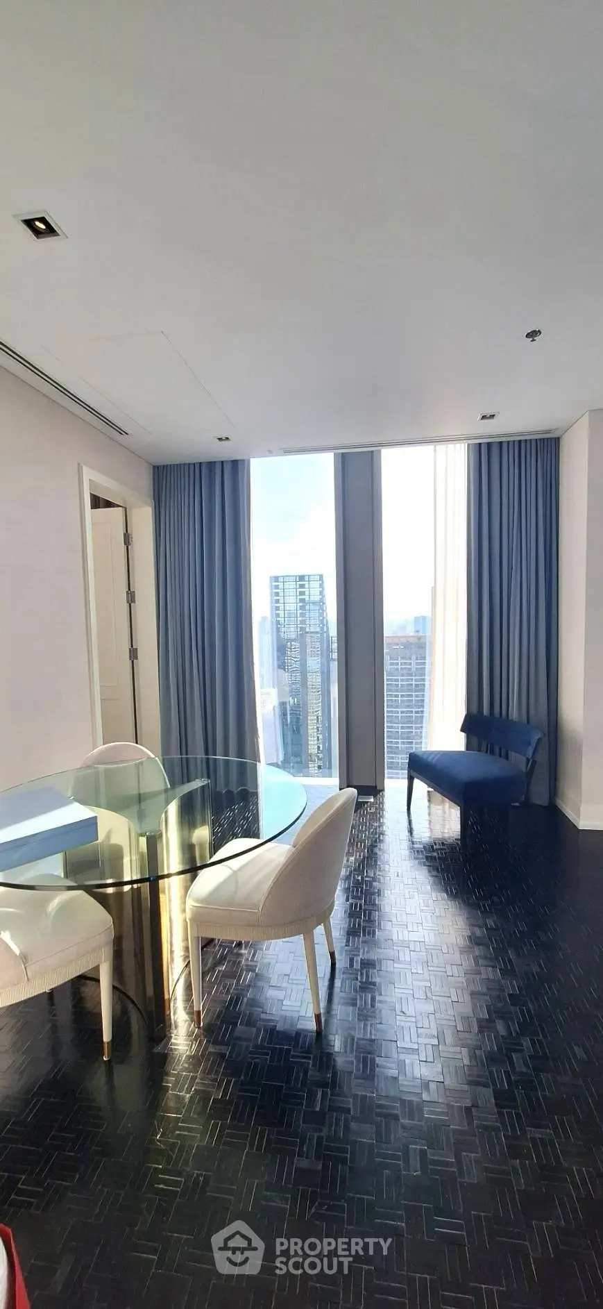 Luxurious high-rise apartment with stunning city view, elegant dining area, and floor-to-ceiling windows.